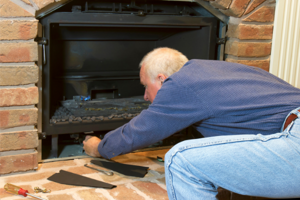 homeowner performing maintenance on their fireplace