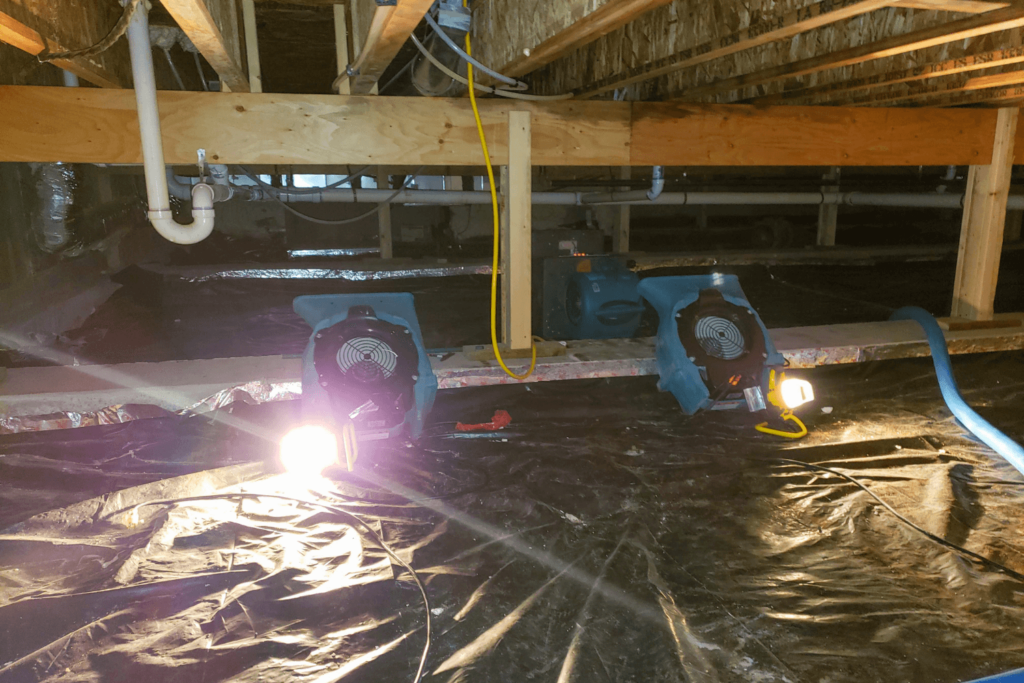 Water damage being repaired in a residential crawl space