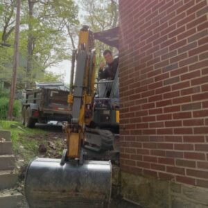 AM Wall Anchor & Waterproofing employee using an excavator