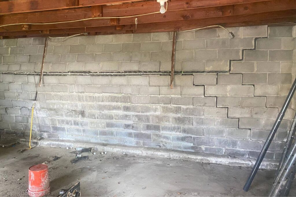 Residential garage brick walls bowing and cracking before foundation repair work begins