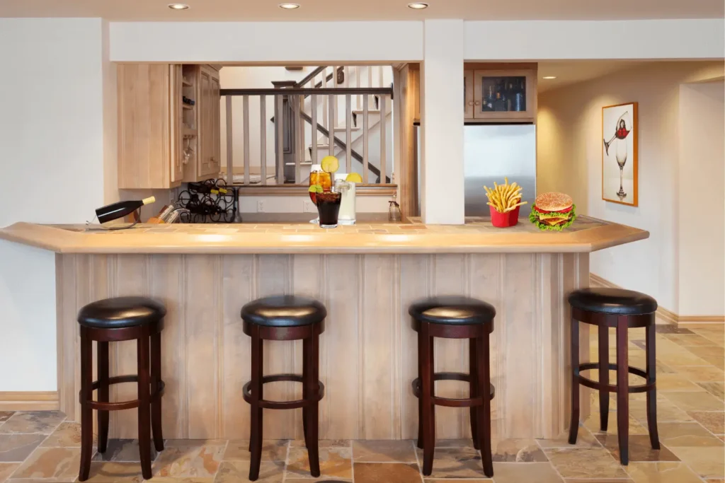 A bar in a basement with food and drinks on the counter top