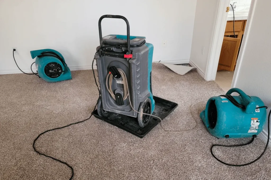 Fans and dehumidifier on the floor of a basement